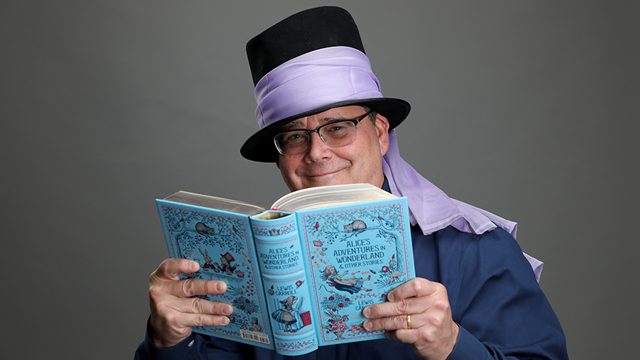 Larry Reynolds holding a copy of the book "Journal of the Plague Year"