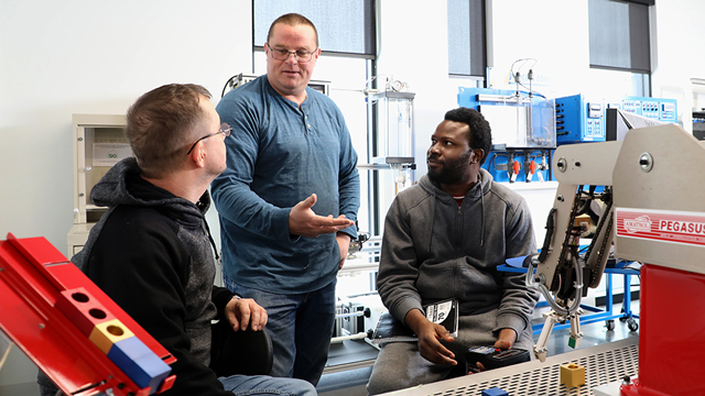 An instructor and two students in the ??? lab