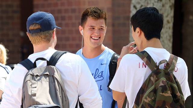 A group of three people visit on the JCCC campus.