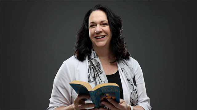 Monica Hogan holding a copy of the book "Parable of the Sower"