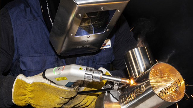 Close-up of a welder using a handheld torch.