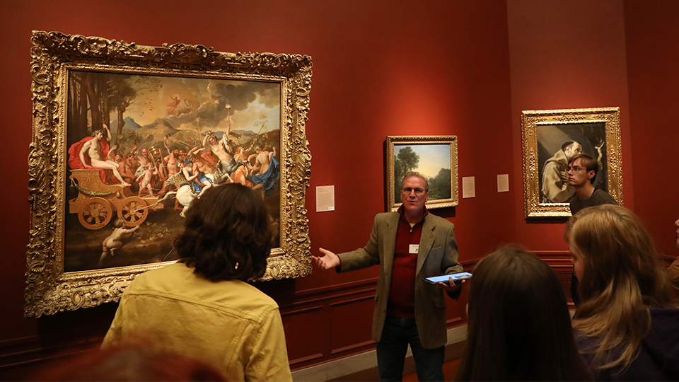 A group listens to a presentation on a painting at the Nelson-Atkins Museum of Art.