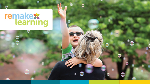 A mother carrying a child reaching for bubbles.