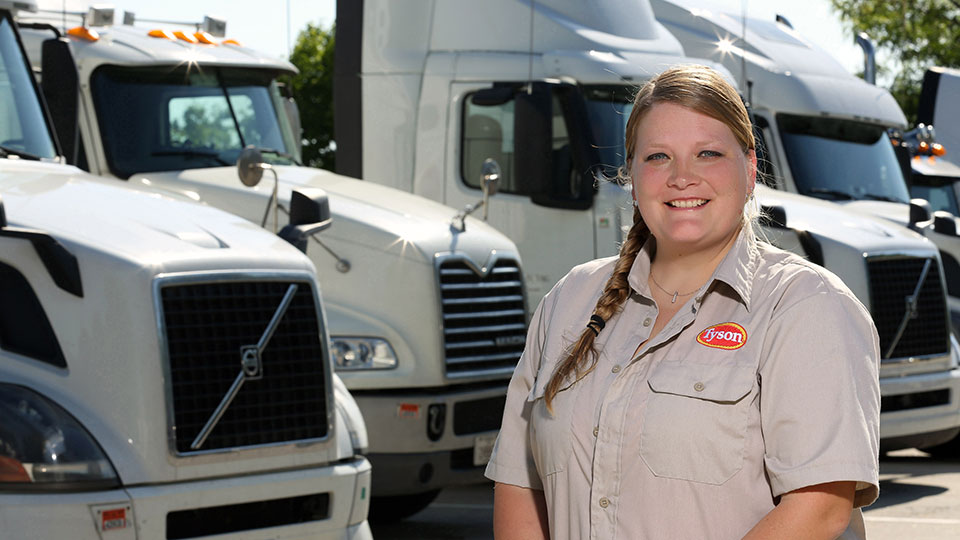 Alison Smith standing in front of a line of semis