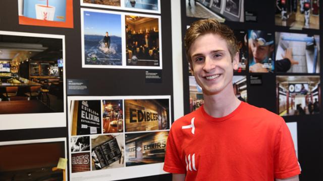 Brend Burford posing in front of graphic design projects