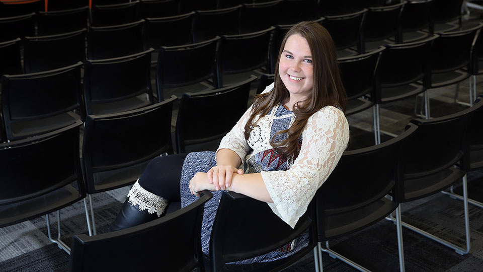 Angela Walker poses for a photo sitting in a chair