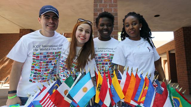 Students in the International Club posing by flags of various countries