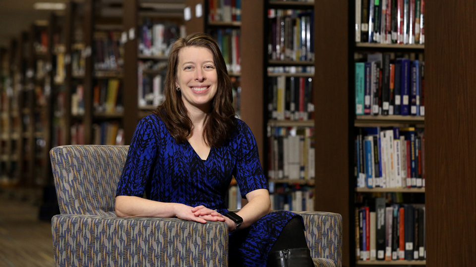 Jessica Tipton sitting in an upholstered chair in the Billington Library