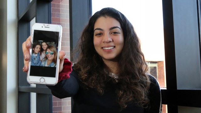 Maya Abuhijleh holds up her cell phone showing a picture of