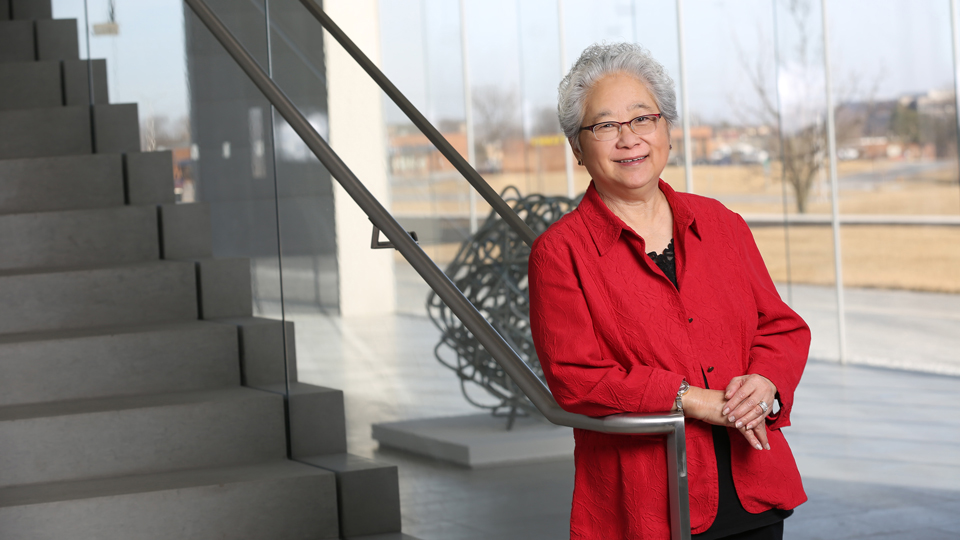 Pat Morrison posing by the staircase on the first floor of the Regnier Center