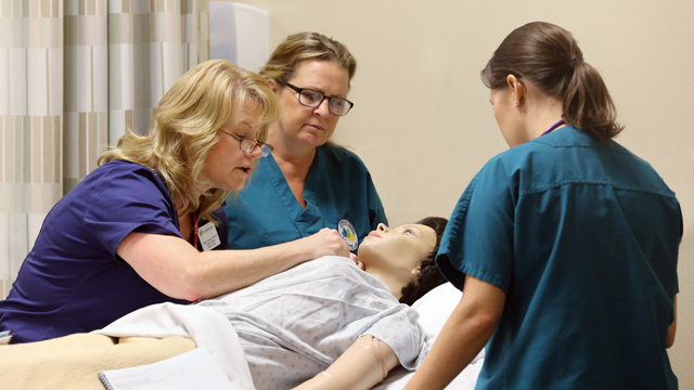 Practical nursing students work on a patient simulator at JCCC’s Olathe Health Education Center (OHEC)