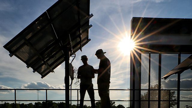 Two students examine solar panels outside CTEC