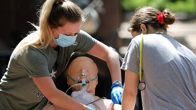 Masked EMS students training using a dummy