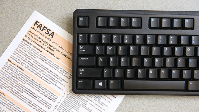 Free Application for Federal Student Aid (FAFSA) application on desk next to keyboard.