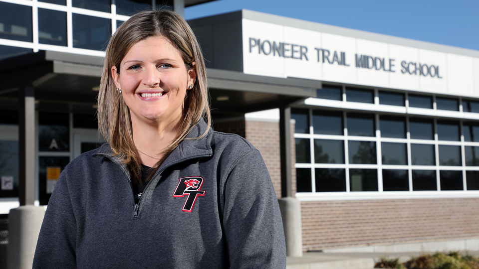 Katie Gerlach standing in front of Pioneer Trail Middle School