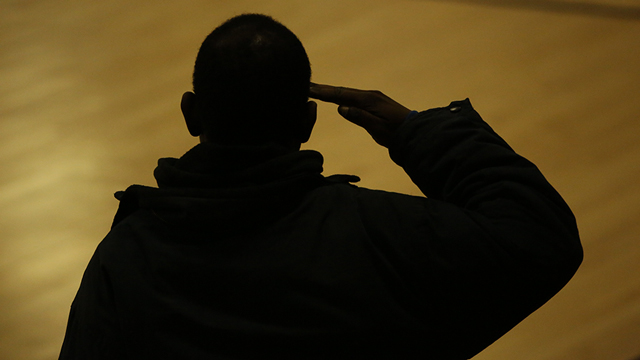 A veteran salutes the flag at a JCCC women’s basketball game.