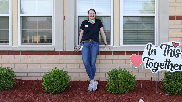 Rachel Schuckman leaning against an outside window of her house