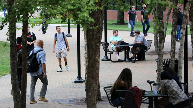 Students walking under the tree in Fountain Square on the JCCC campus