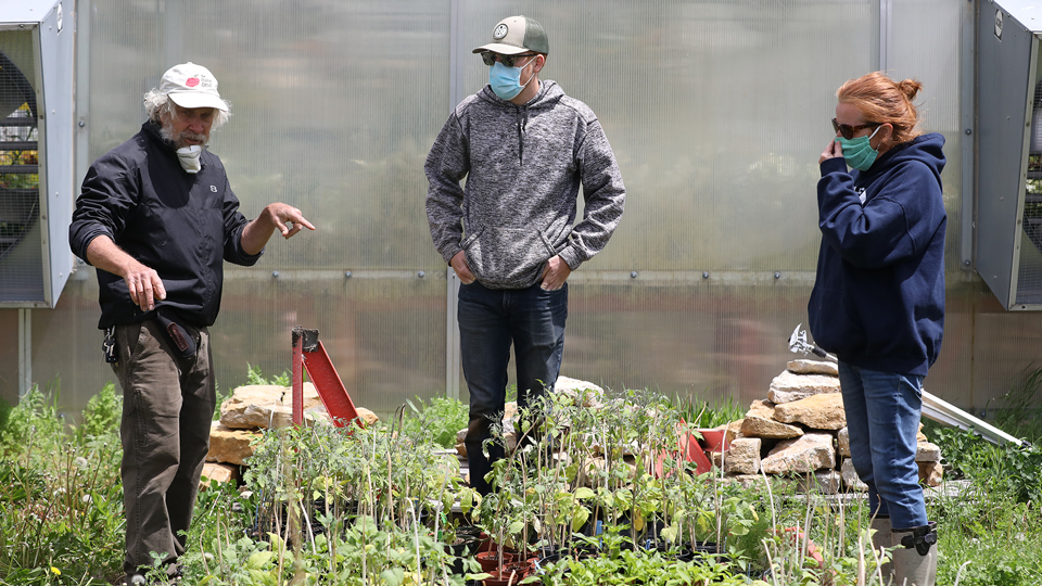 Rick Mareske watering plants on the Open Petal Farm