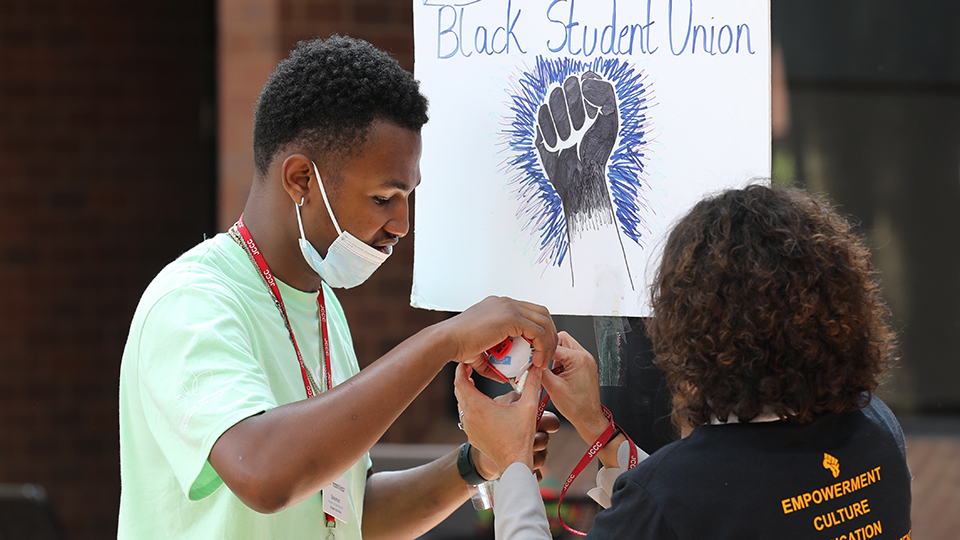 Solomon Web hanging a Black Lives Matter poster