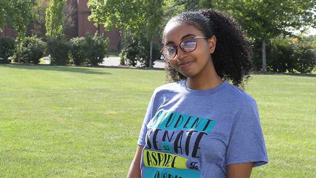 Mahlet Mulugeta, wearing a student senate t-shirt, standing outside