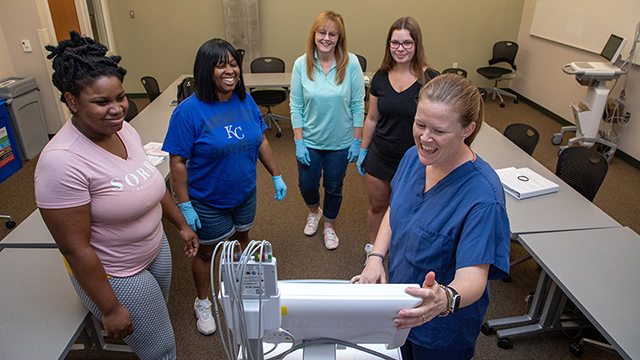 Nursing students learning about an ECG machine