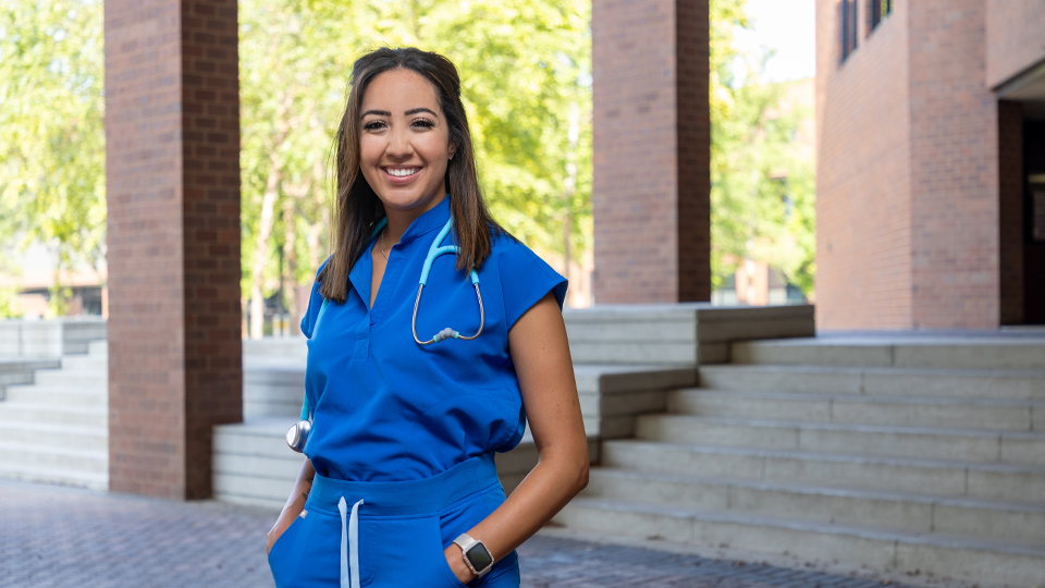 Kristina Davidson standing on the steps of the COM building