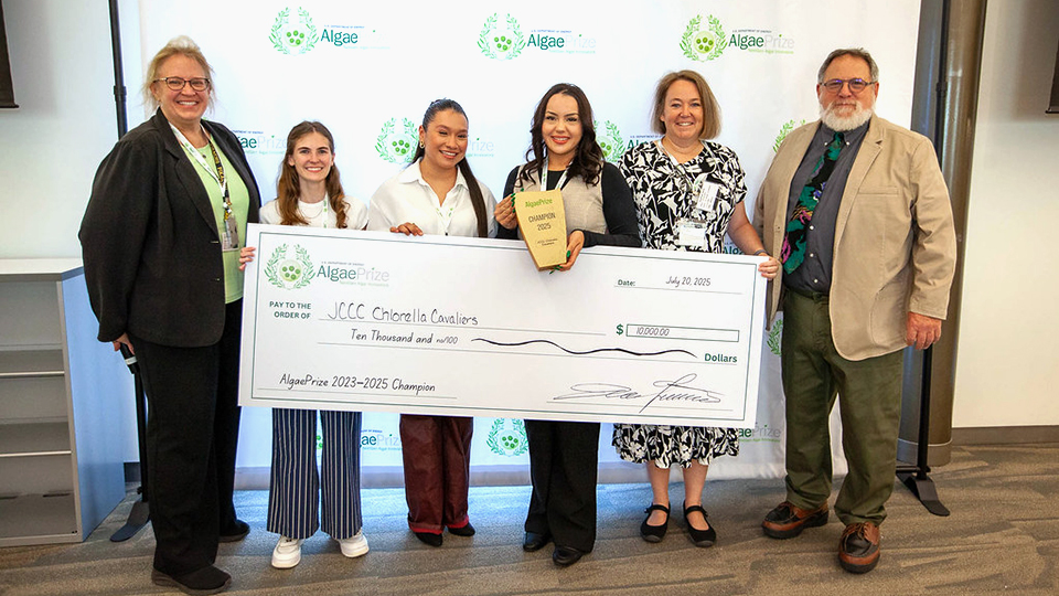 ChlorellaCavs team posing with a giant check representing their win