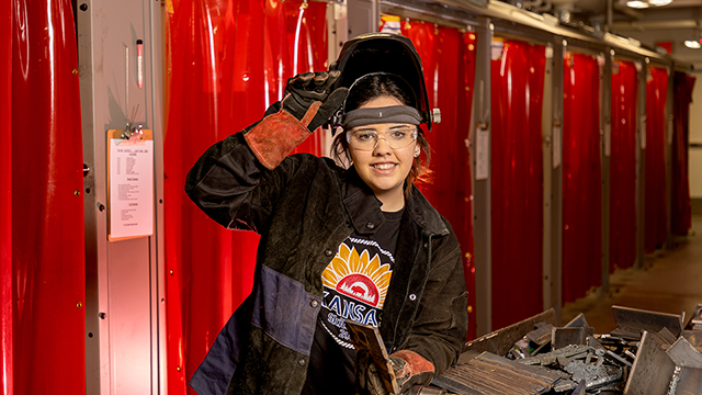 Jasmine Gambhir posing wearing her welding helmet and gloves