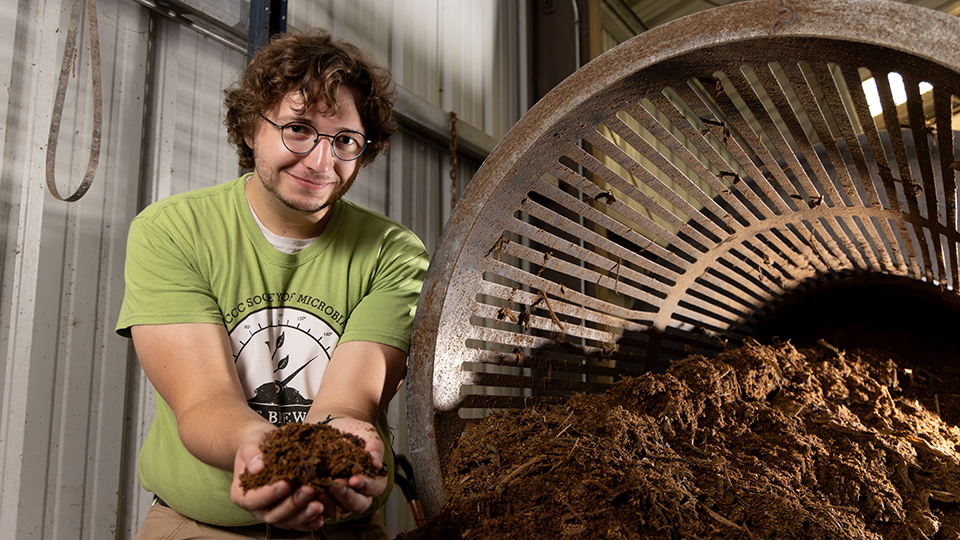 Eli VanDeCreek holding a handful of composted soil.