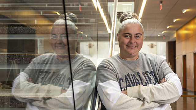 A smiling Raina Lupton is leaning against the stairway in the Regnier Center