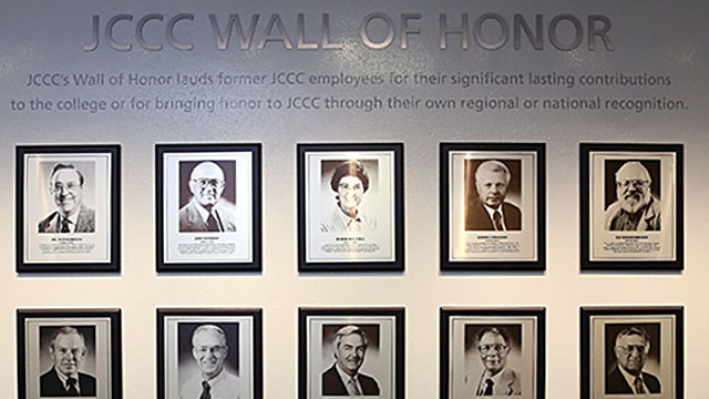 2 rows of black and white portraits on the wall of honor at JCCC