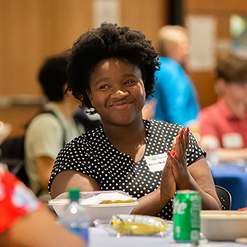 Scholar Lunch - scholarship recipient smiles and claps her hands