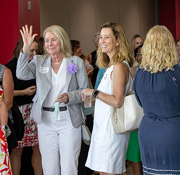 a group of women greeting each other at the scholarship event