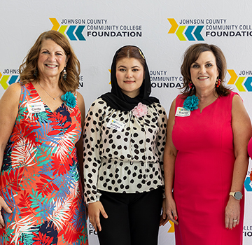 four women standing in a line pose for a picture