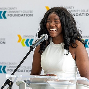 a smiling scholarship recipient giving a speech