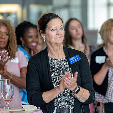 a crowd of women clapping