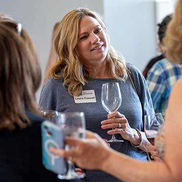 women chatting a sipping wine at the scholarship event