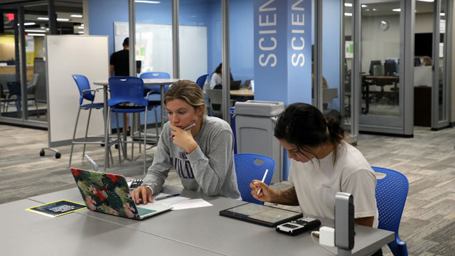 Two students studying at a table in the Science Resource Center