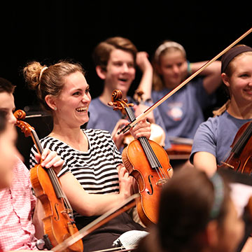 Smiling, seated violinists