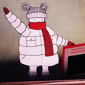 Child bundled up in warm coat and scarf waving