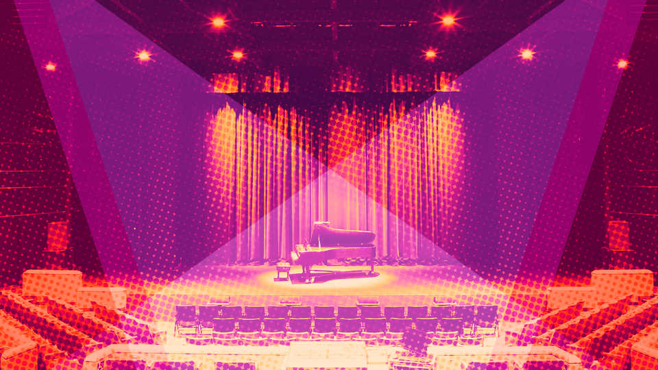 An empty piano on stage in an empty theater.