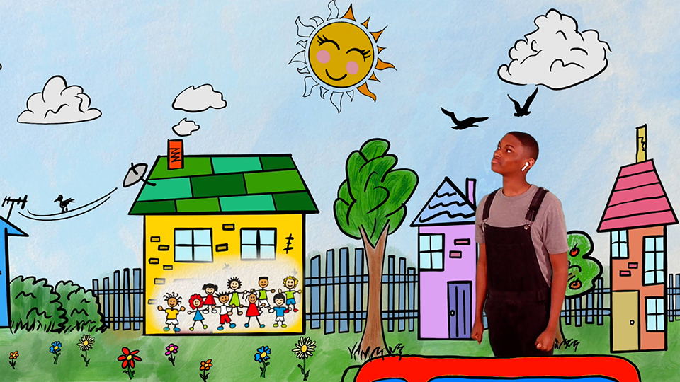 Jabari stands in front of a colorfully illustrated neighborhood.