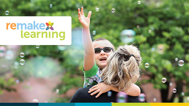 a young boy being carried by his mother smiles and reaches for floating bubbles on a bright summer day