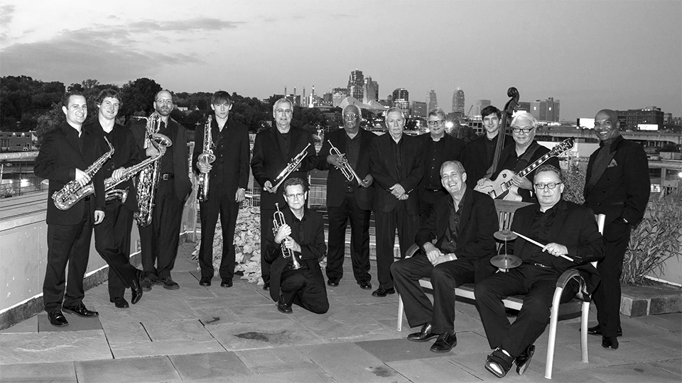 The members of Vine Street Rumble pose with their instruments on a balcony overlooking downtown Kansas City.