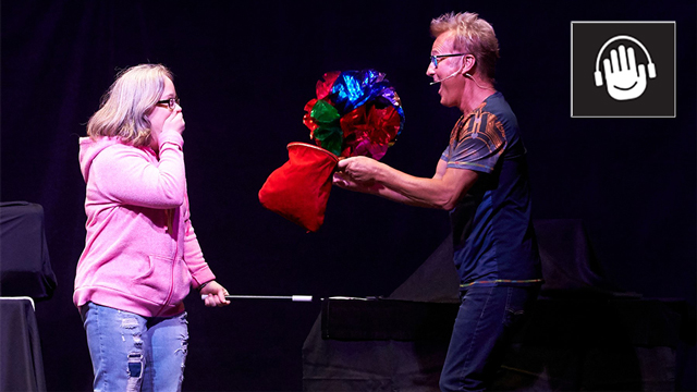 Magician Kevin Spencer pulls flowers out of a hat.