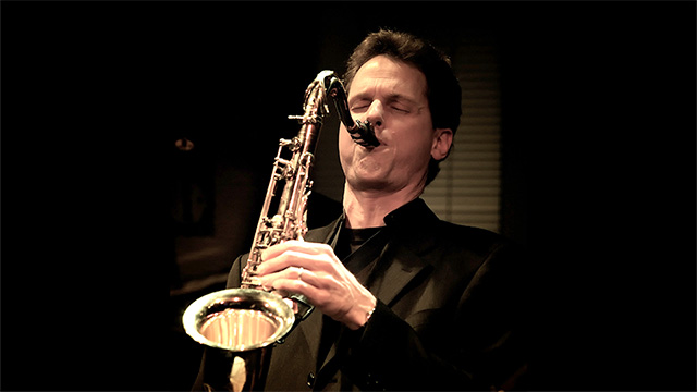 Doug Talley playing a saxophone.