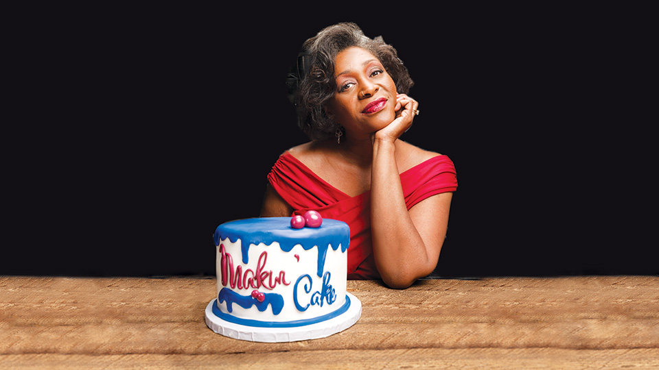 Dasha Kelly Hamilton sitting at a table in front of a cake