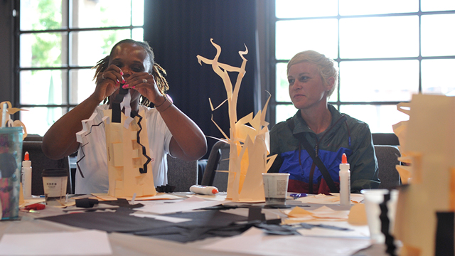 two teachers working on paper sculptures during a workshop
