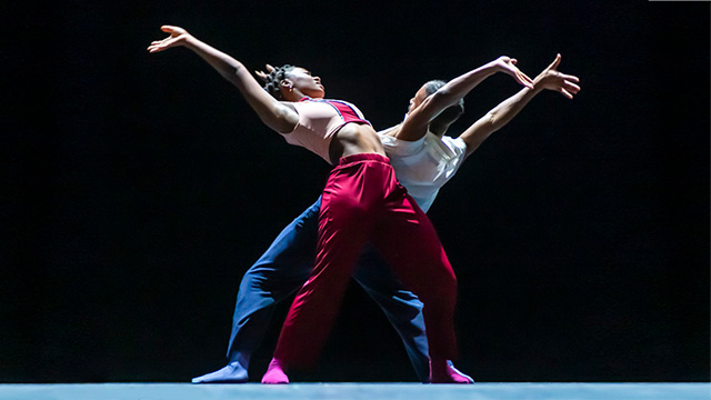  2 dancers on a black stage.